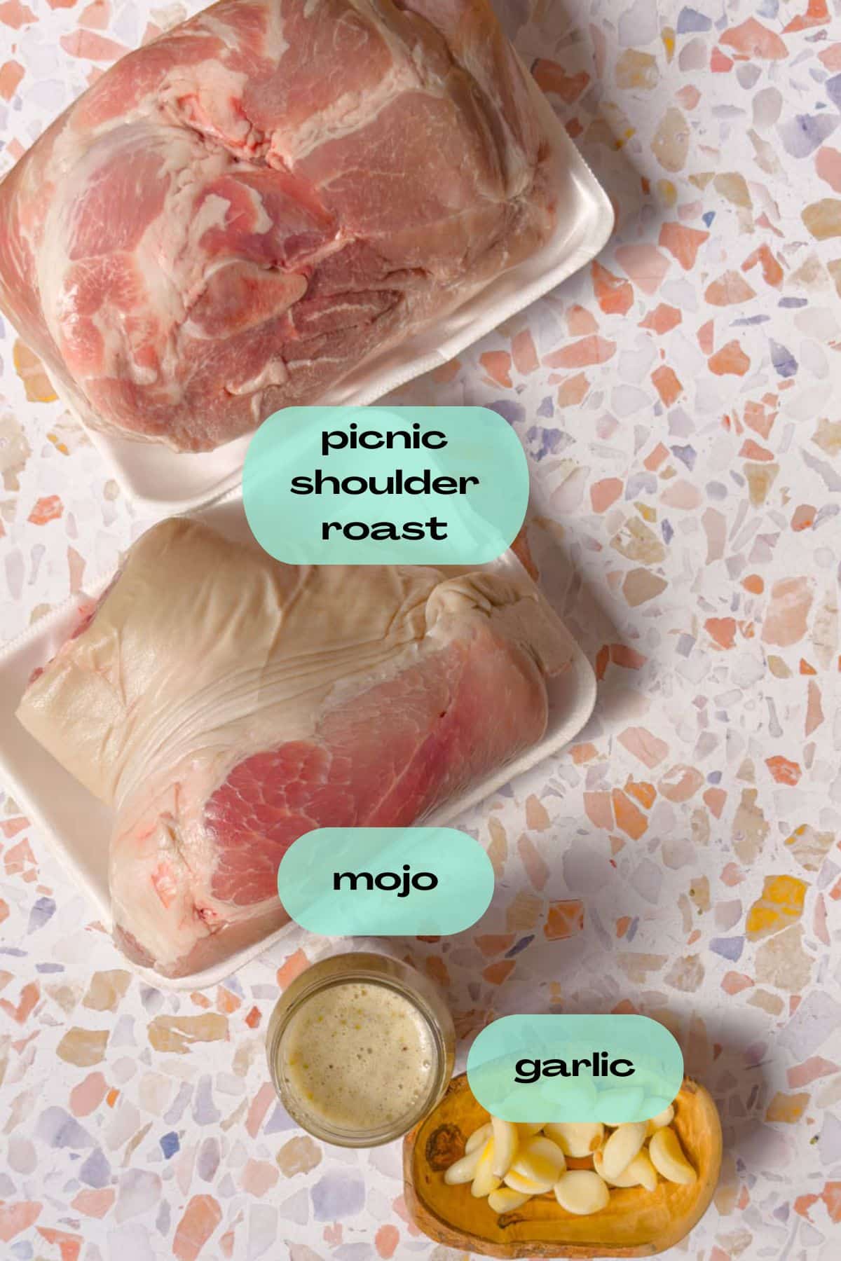Ingredients to make pernil: Picnic Shoulder Roast, Mojo, and garlic.