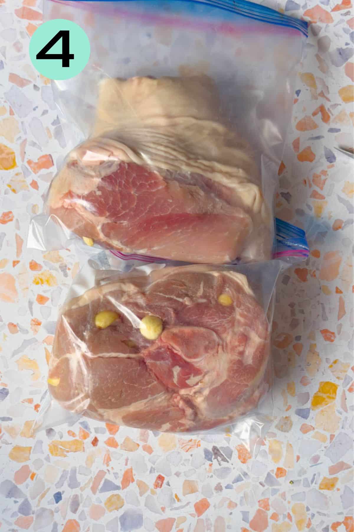 Two 4.5 pound pieces of picnic roast stuffed inside a ziplock bag for marinating.