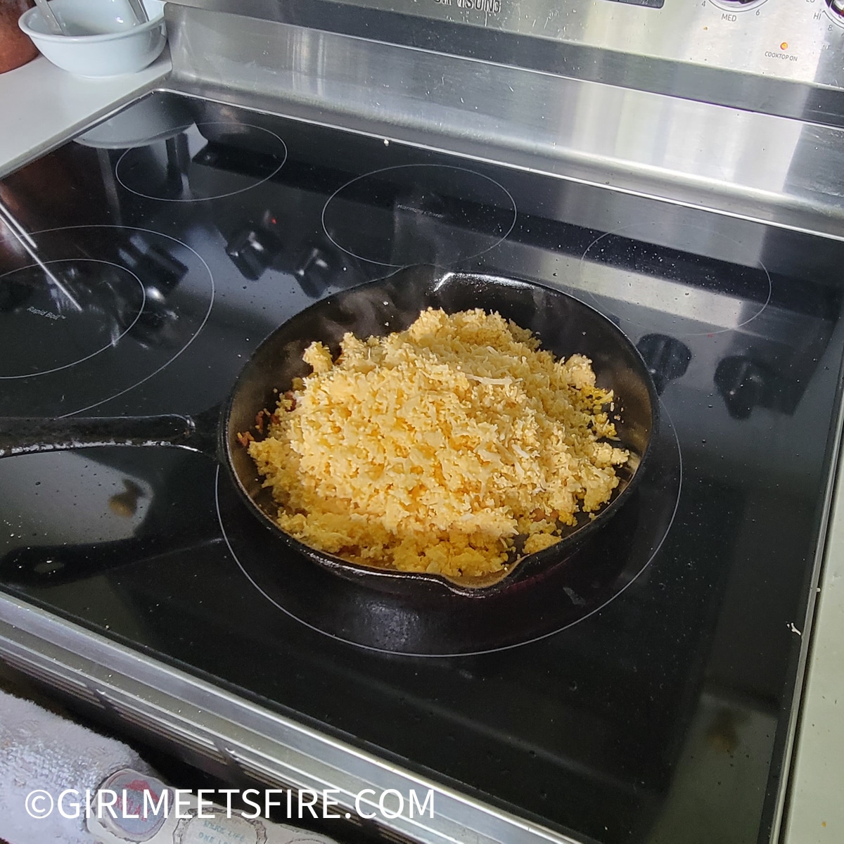 Adding cauliflower to the skillet once the onions and garlic are translucent and soft.