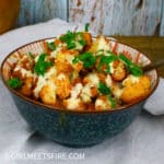 a bowl of cauliflower tossed in a brava sauce