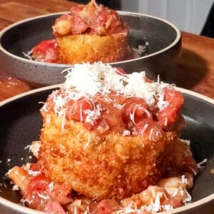 Two bowls with Crispy eggplant boats topped with shrimp stew and shredded parmesan cheese