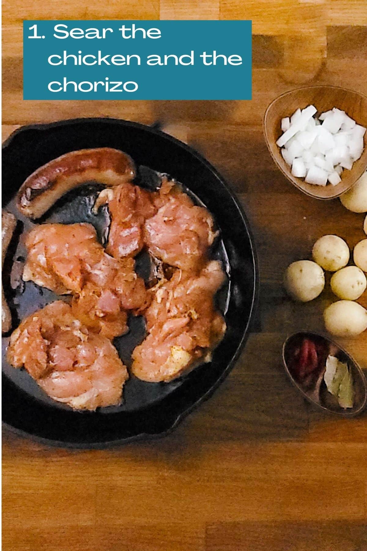 searing chicken and chorizo in a cast iron skillet. view of ingredients that will be added, like onions, potatoes, tomatoes paste and bay leaves.