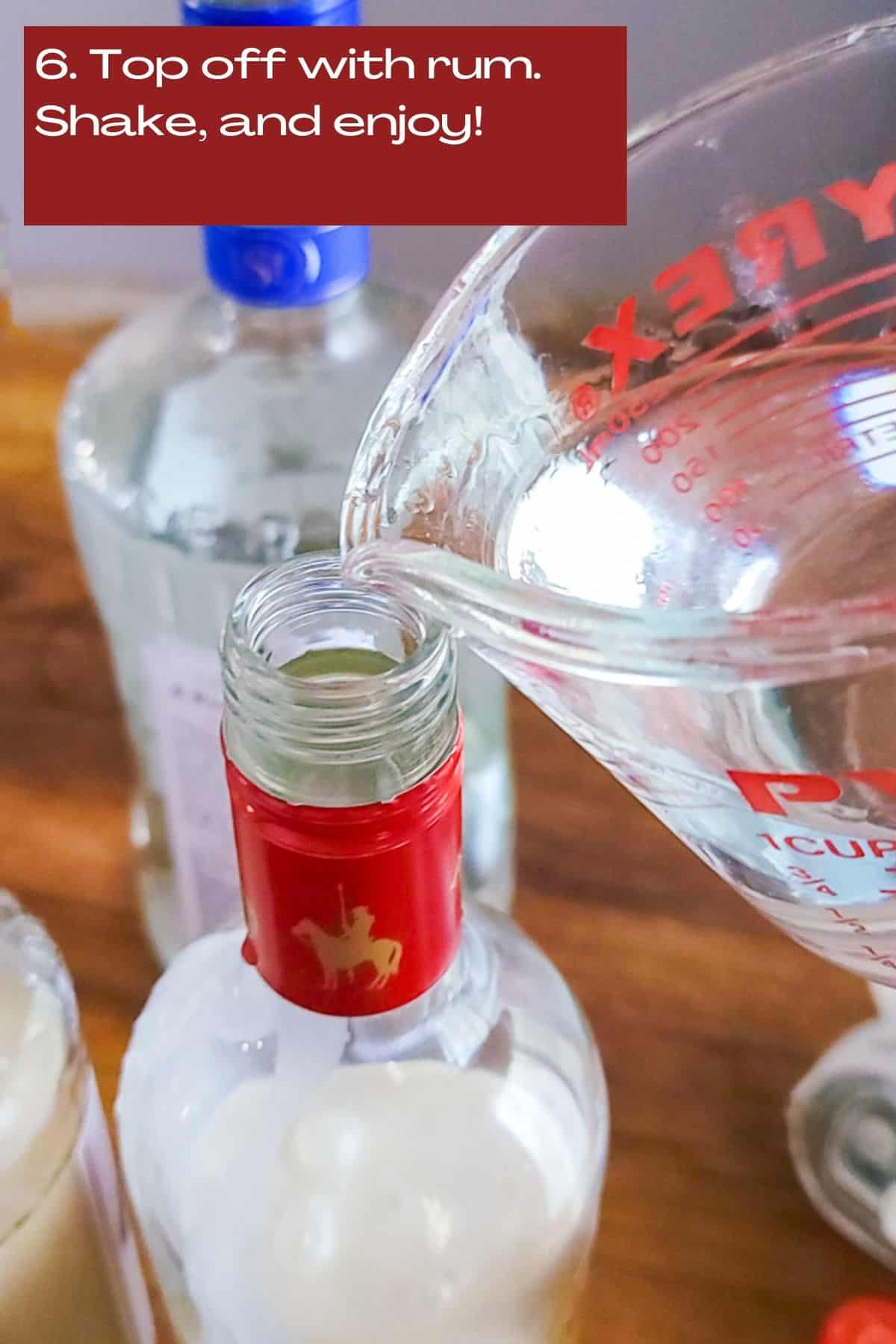white rum being pour into a bottle that has coquito mix
