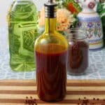 A bottle of achiote oil is at the center of the image, with a mason jar full of achiote seeds and a bottle of oil behind it.