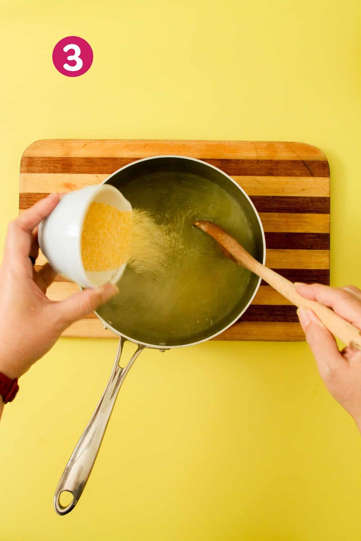 Pot with hot broth and sofrito with cornmeal being added as mixing.