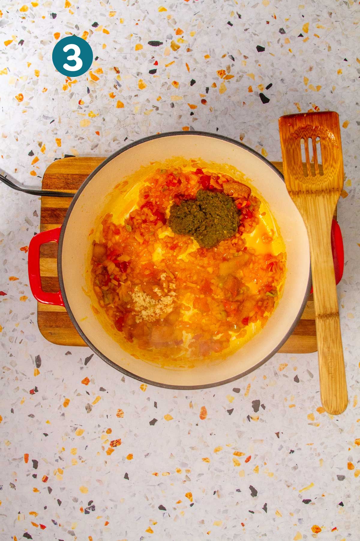 A dollop of green sofrito and minced garlic is added to the sautéed base.