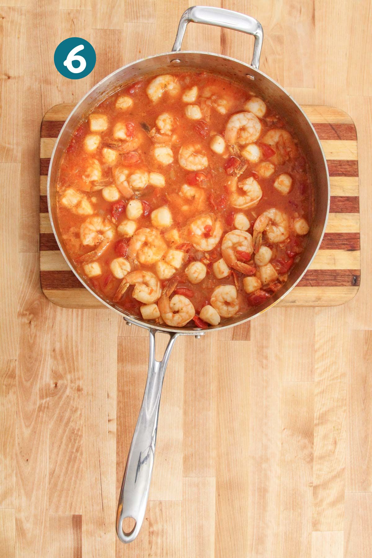 Finished shrimp and scallop stew in a tomato-based broth, ready to serve.