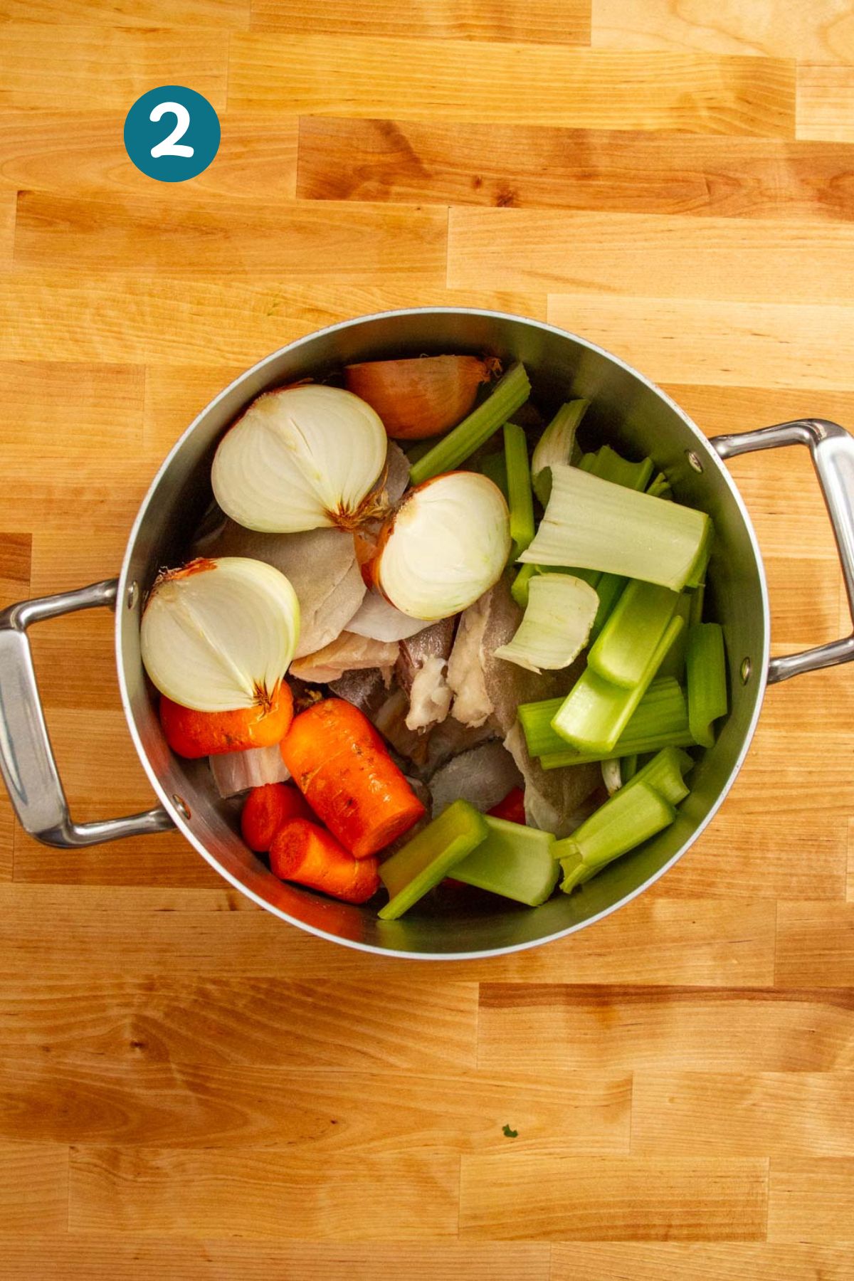 Onions, carrots, and celery were added to the pot with the fish heads.