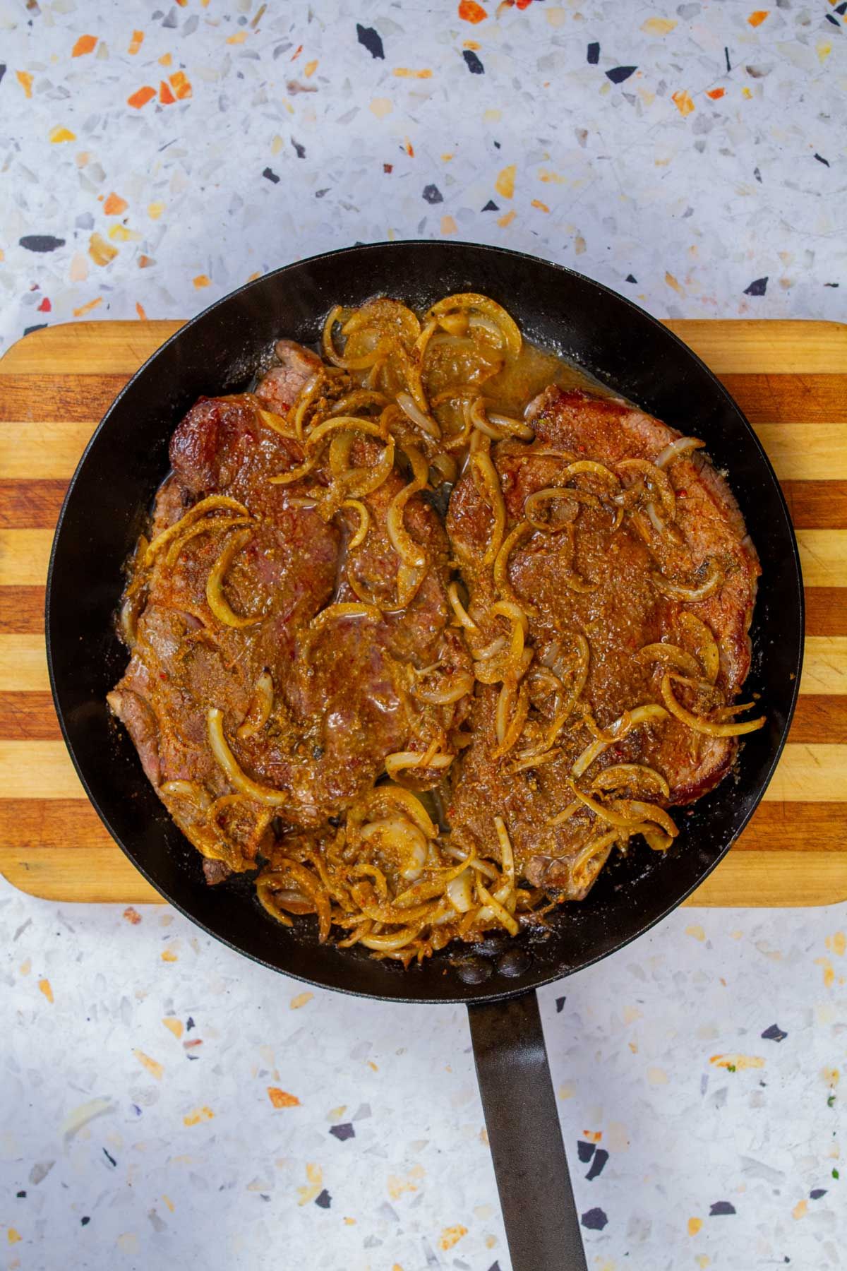 Biftec encebollado simmered with onions in a rich pan sauce.