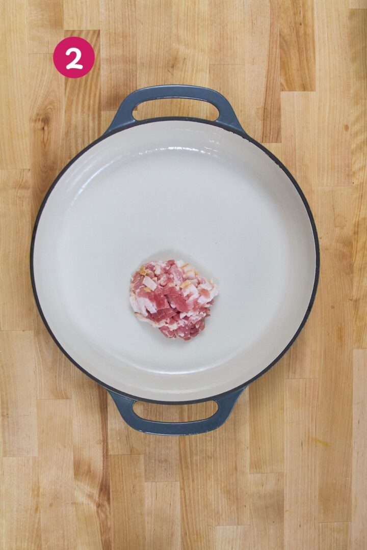 Overhead view of diced bacon beginning to render in braiser, labeled with step 2.