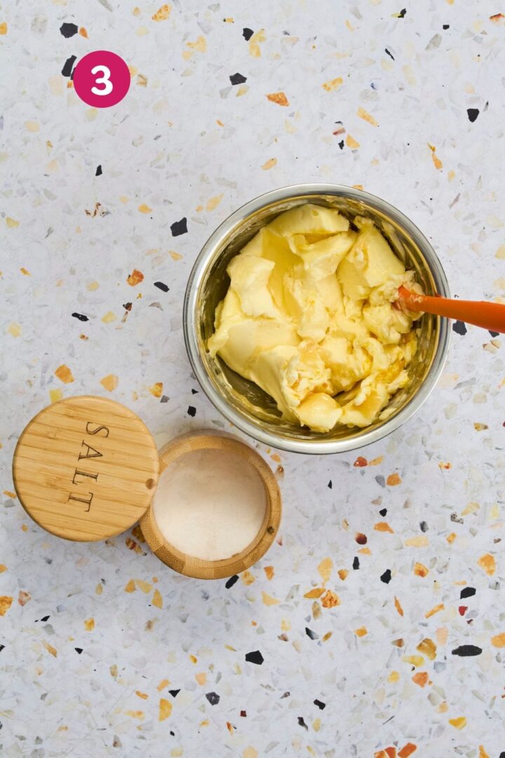Adding pinch of salt to orange honey butter mixture in mixing bowl - step 3.