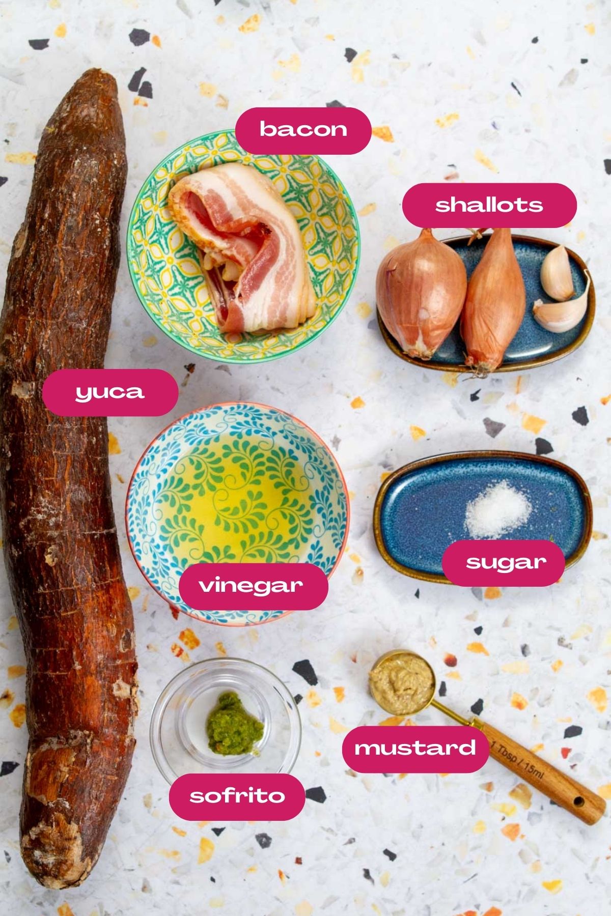 All ingredients for the yuca salad lay out, including whole yuca root, bacon strips, shallots, vinegar, sugar, mustard, and sofrito.