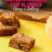 Peanut butter chocolate chip blondie squares stacked on a yellow surface with a yellow flower, overlaid with bold pink text reading "Classic Peanut Butter Chocolate Chip Blondies Chewy and Buttery" and a girlmeetsfire.com URL banner.