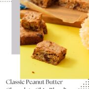 Peanut butter chocolate chip blondie squares on parchment paper over a striped wooden cutting board on a yellow surface, with a Pinterest graphic in a split layout reading "Classic Peanut Butter Chocolate Chip Blondies, Chewy and Buttery" and girlmeetsfire.com with a dotted border design.