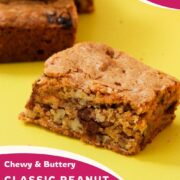 Close-up of a peanut butter chocolate chip blondie square showing a dense pecan and chocolate chip interior, with a pink curved bottom graphic reading "Chewy and Buttery Classic Peanut Butter Chocolate Chip Blondies" and girlmeetsfire.com.