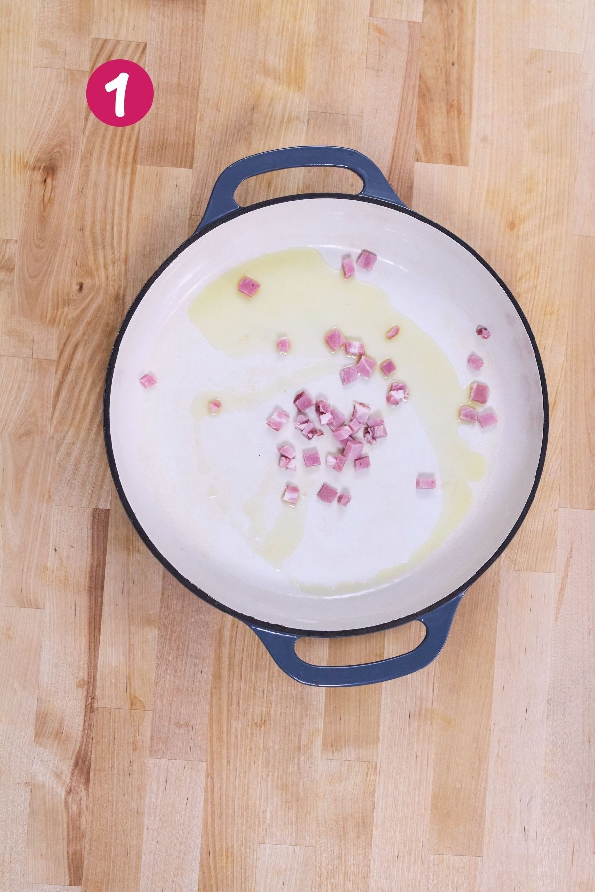 Diced ham and olive oil in a Dutch oven before cooking.