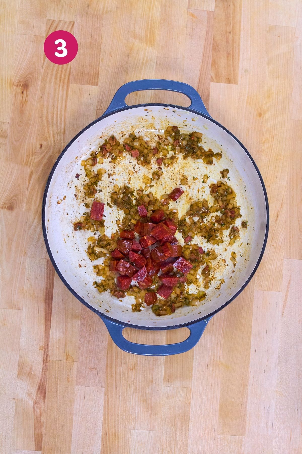 Diced chorizo was added to sautéed onion, ham, and sofrito in a Dutch oven.